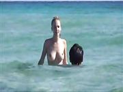 Una giovane ragazza è in topless in spiaggia